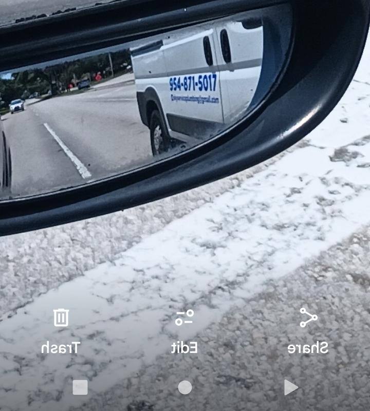 DW Service Plumbing van captured in side mirror reflection