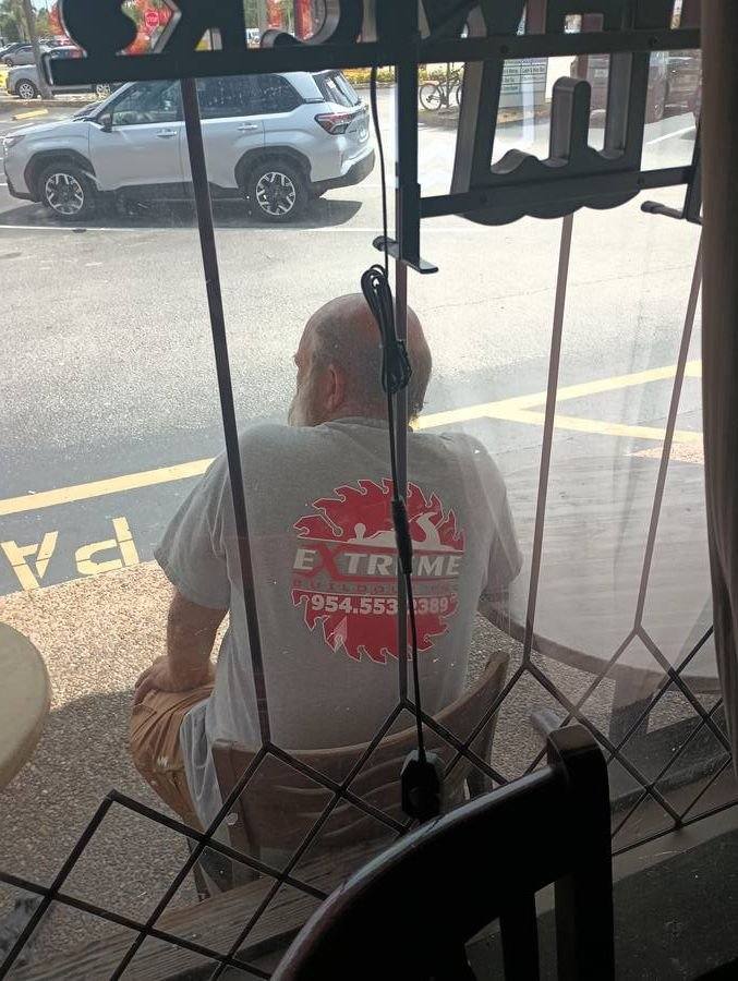 Extreme Building employee t-shirt spotted through restaurant window